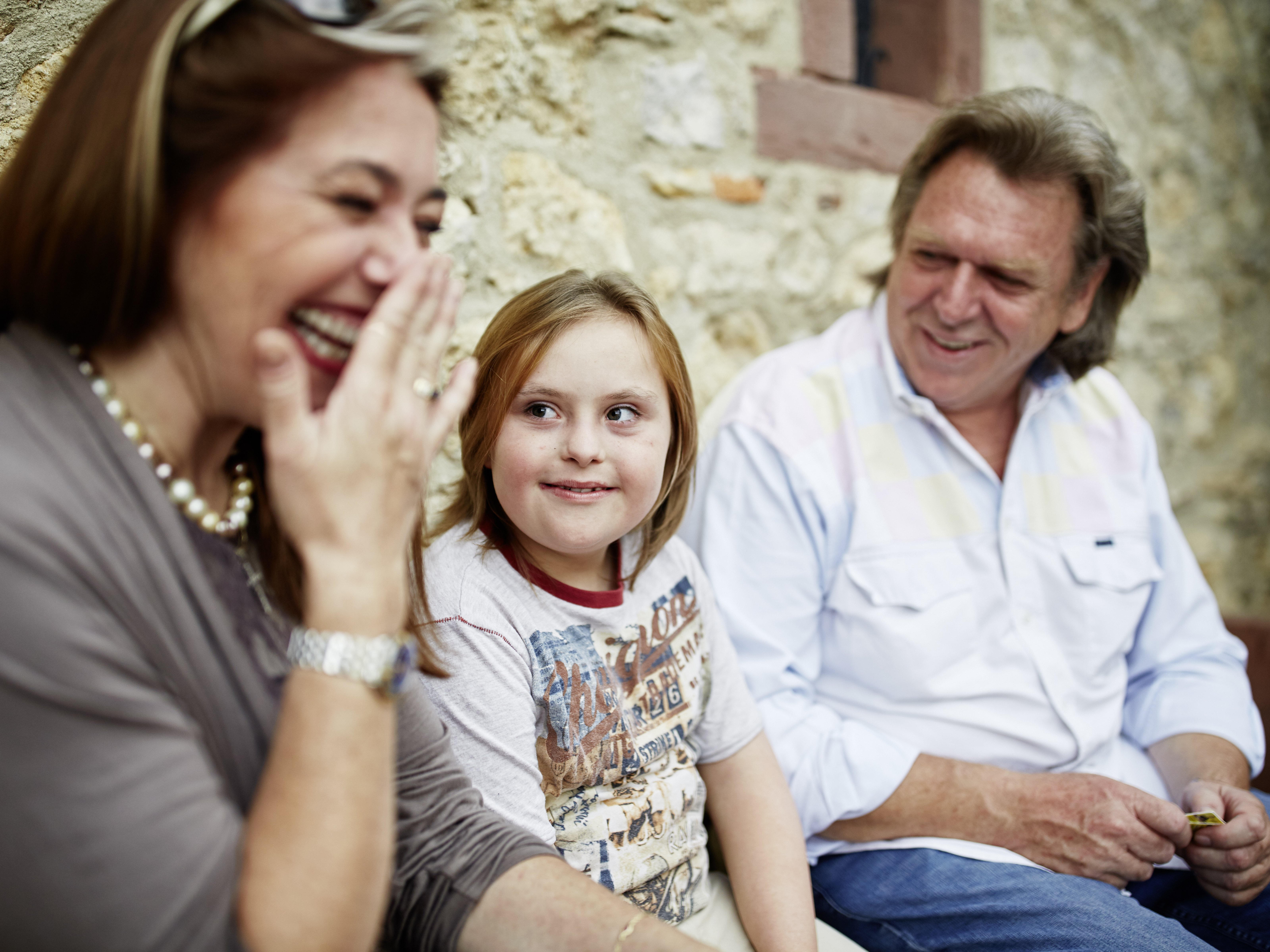 Foto von einem Mädchen mit Down-Syndrom mit seinen Eltern.