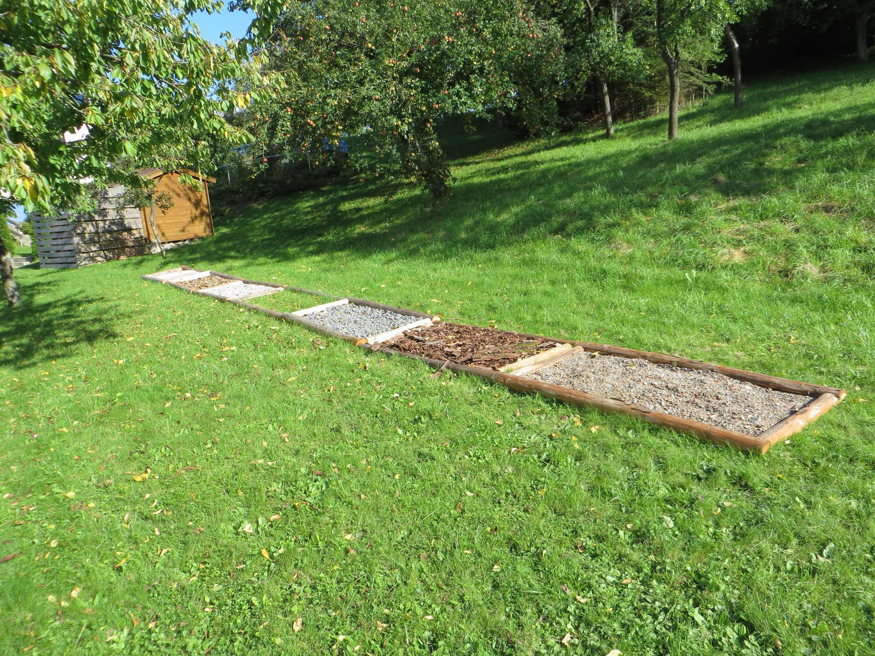 Foto des Barfuß-Pfads im Garten. Man kann über verschiedene Materialien laufen und diese spüren.